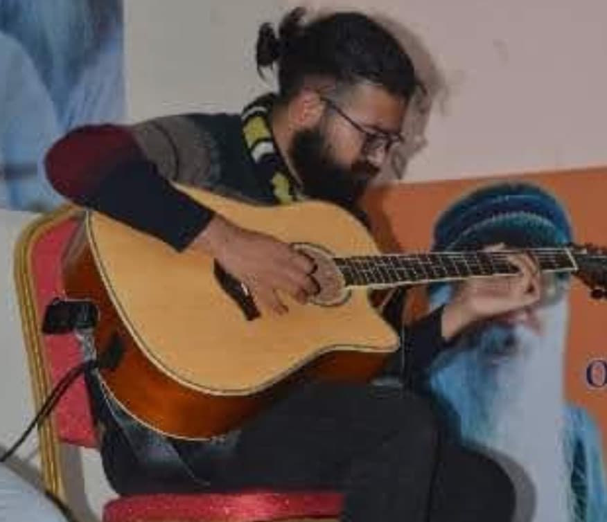 Playing acoustic guitar seated