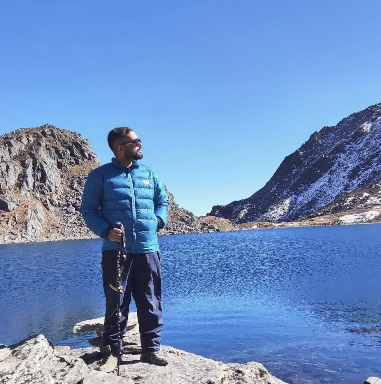 Standing by a blue mountain lake